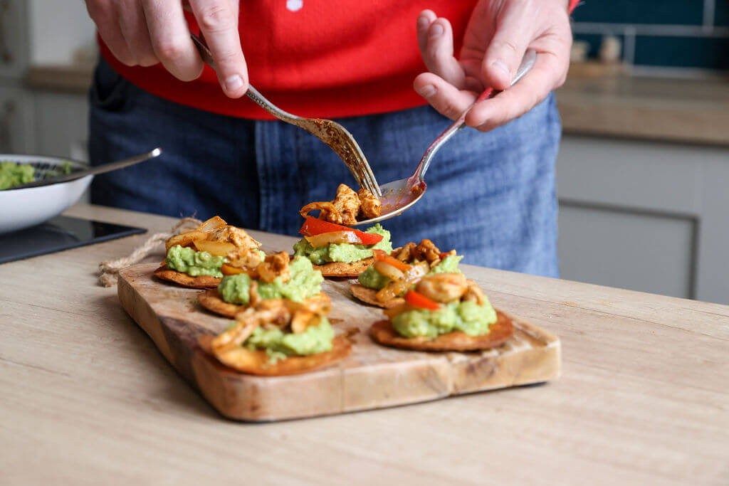 Tasty sharers or starters for a Latin feast, fajita chicken and guacamole on a crisp oven baked tostada.